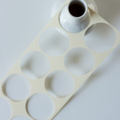white vase and paper with circles