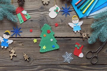 Different handmade christmas toys from felt with your own hands on wooden background. New Years Childrens DIY concept. Xmas tree decoration, gift or greeting card.