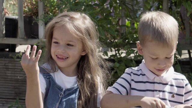 Portrait of Cute Little Three Children sitting on the beanch Garden. Cheerful Carefree Childhood. Preschool Siblings Friends Feeling Free Funky, Good Emotions Life. Home Dancing. Friendship Kids