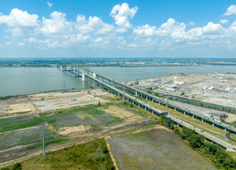 Fototapeta na wymiar Aerial view of the Delaware Memorial Bridge spanning across the Delaware river connecting to the New Jersey turnpike with a giant chemical plan in the background