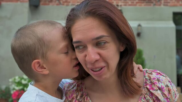 The boy whispering a secret in his ear. 4k video footage in slow motion
