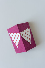 Fototapeta na wymiar paper shapes wth polka dots on folded pink paper card