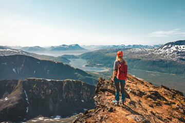 Woman hiking in Norway enjoying aerial view on cliff outdoor Travel adventure tour active vacations...