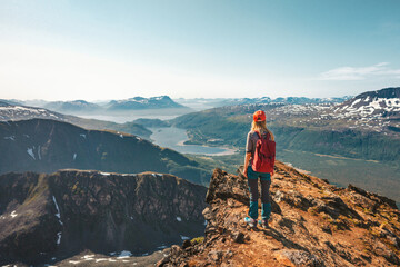 Fototapeta premium Woman hiking in Norway enjoying aerial view on cliff outdoor Travel adventure tour active vacations healthy lifestyle climbing to Hamperokken mountain sustainable tourism 