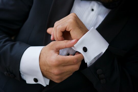 Men's hands correct shirt with cufflinks
