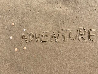 on the beach is carved with letters in the smooth sand the writing adventure