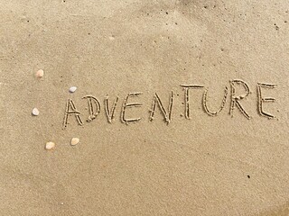 on the beach is carved with letters in the smooth sand the writing adventure