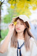 portrait cheerful smiling asian woman with summer blooming golden shower flower
