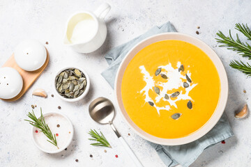 Traditionl Pumpkin soup puree with cream. Top view image at white table.