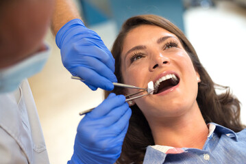 Young woman checking her teeth at the dentist clinic