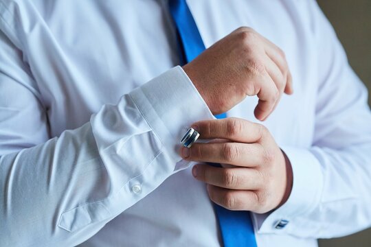 Men's hands correct shirt with cufflinks
