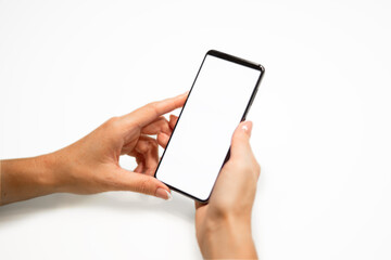 beautiful female hands with manicure hold a smartphone with a white screen on a yellow background.
