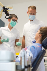 Young woman checking her teeth at the dentist clinic