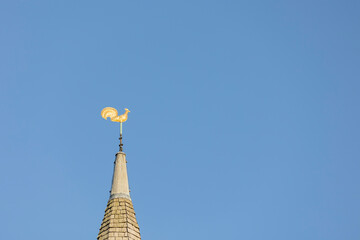 Weather vane, gold cockerel on a church spire set against a blue sky, copy space © © Raymond Orton