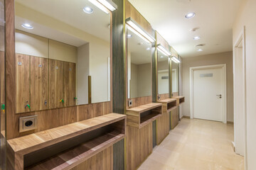 Changing room in the SPA center. Large illuminated mirrors along the wall.