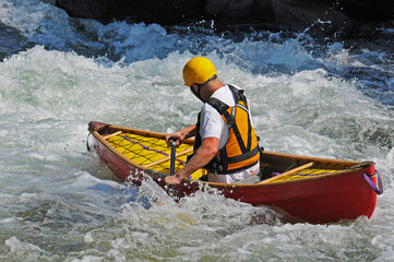 Man in canoe in rapids