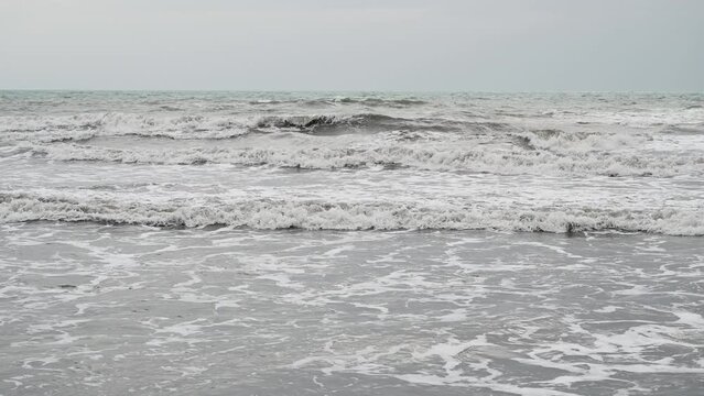 Polluted sea. Muddy sea water after the rain. Stormy weather on the coast. Grey color of ocean. 