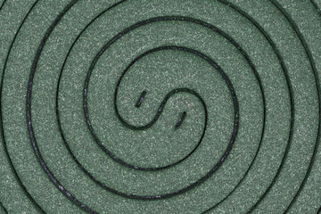 Fototapeta na wymiar An extreme close-up of two tightly packed green Mosquito coils postioned flat and straight on, looking a bit like the Yin and Yang symbol 