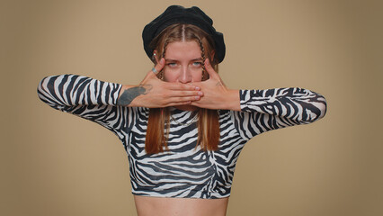 I will not say anyone. Frightened young woman closing her mouth with hand, looking intimidated...