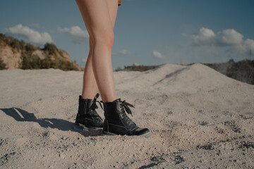 girl walking on sand. boots and legs. High quality photo