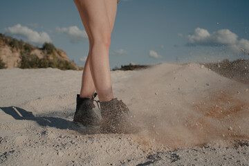 girl walking on sand. boots and legs. High quality photo