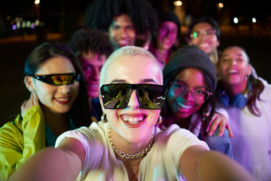 Multiracial group of people taking a selfie in a disco party. Happy friends having fun together in a night club.