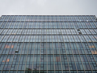 Fototapeta na wymiar The windows of a high-rise building. Building monolith. Background from architecture