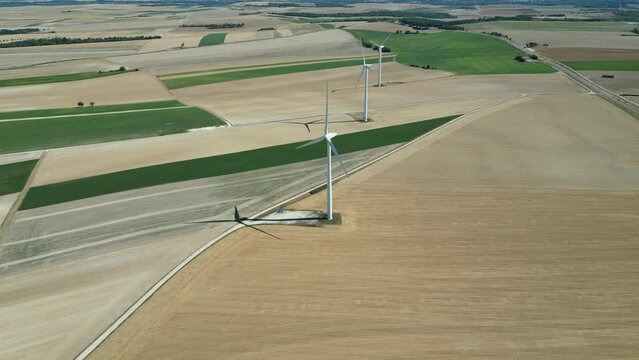 View from a drone of a wind farm in the countryside of France in the middle of the fields