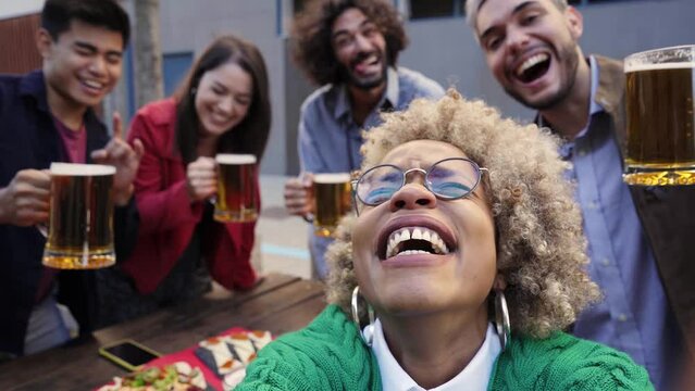 Young African American girl takes a cell phone photo with her multiracial group of friends. Concept of friendship, having fun.