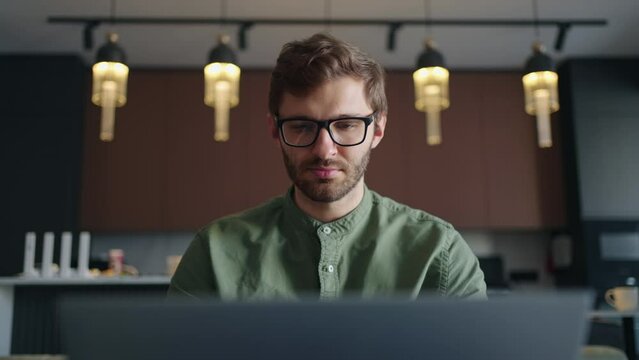portrait of man with glasses surfing internet by laptop at home, typing search query in browser