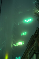 Glowing tall building in the fog. A series of photos of foggy Kyiv.