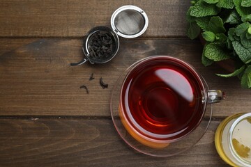 Cup of hot aromatic tea with mint and honey on wooden table, flat lay. Space for text