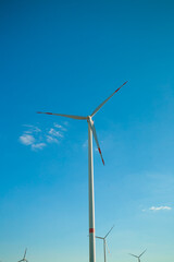 Wind generator on a blue sky background.Alternative natural energy source. Wind energy price.Green renewable energy cost.Windmill renewable energy.