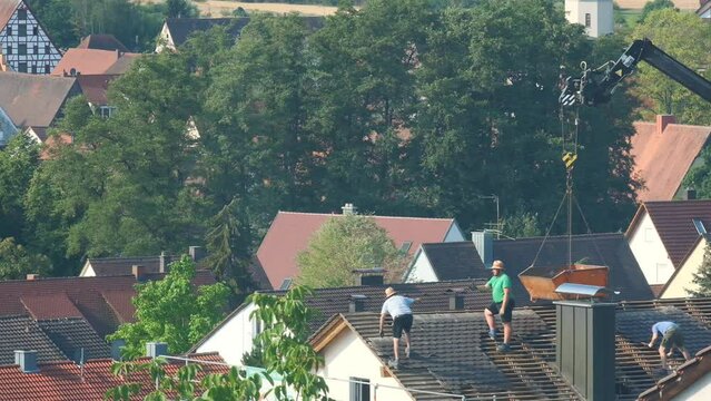 builders on the roof of the house.Roof repair and tile replacement. 4k footage
