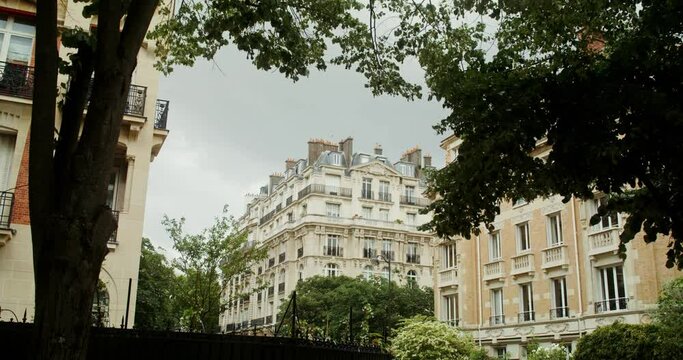 Beautiful view of the picturesque street of paris with traditional historical buildings among the dense green foliage of the trees. France Paris. 4k video, red komodo