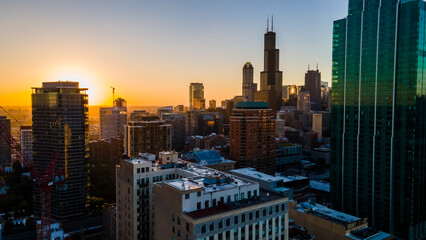 Fototapeta premium Chicago, IL USA September 1 2022: establishing aerial drone footage of Chicago downtown during sunset on a mid summer evening. the contemporary buildings are beautiful to watch for tourist 