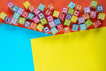 Wooden multicolored blocks with letters on orange background. Education for preschooler, reading, alphabet. Back to school concept