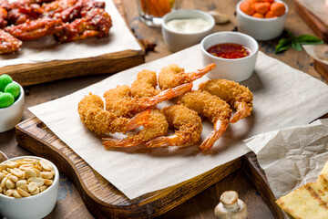 fried tempura shrimps on the board with sweet chili sauce on wooden table