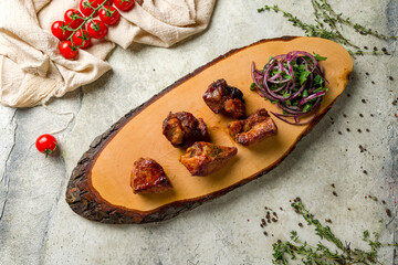 Kebab of pork with red onion on the board on stone table top view