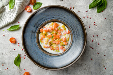 gnocchi with seafood and fresh salmon on plate on grey table top view