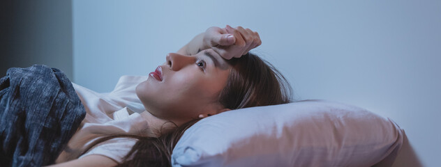 Asian women opened eyes lying on the bed have an insomnia problems.