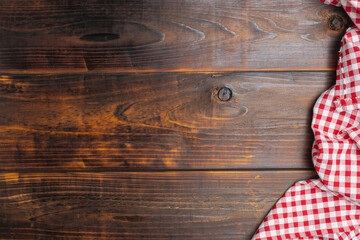 Tablecloth red and white checkered squared on old wooden, top view. With copy space for design menu of food for restaurant. Fabric texture background. Texture of cotton fabric.