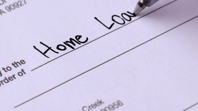 Close-up shot of a check being writen for a home loan.