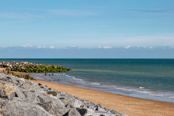 The shingle beach at Jury's Gap in East Sussex with the rocks of the seawall in the foreground