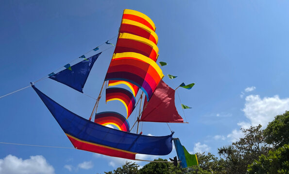 flying ship, rainbow colored ship kite flies on the blue sky and cloud