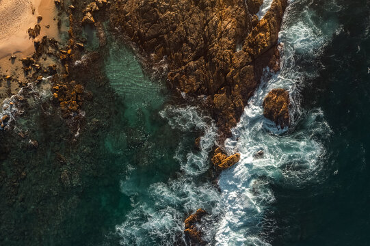 Aerial view Top down seashore big wave crashing on rock cliff