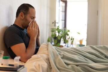 Sick Caucasian man self isolating and social distancing in quarantine lockdown during coronavirus co