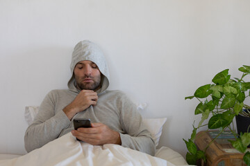 Sick Caucasian man self isolating and social distancing in quarantine lockdown during coronavirus co
