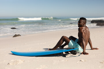 African American man and surf board on the beach