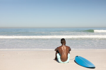 African American man and surf board on the beach